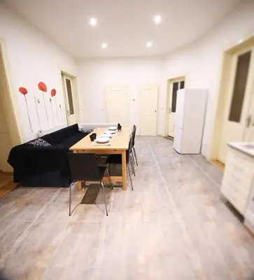 a living room with a table and a black couch at Vltava Apartments Prague 7 in Prague