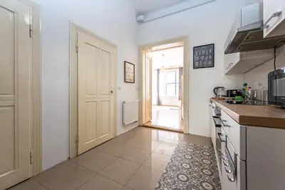 a kitchen with a door leading to a hallway at Vltava Apartments Prague 7 in Prague
