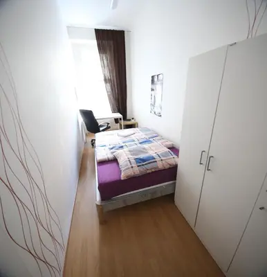 a small bedroom with a bed and a closet at Vltava Apartments Prague 7 in Prague