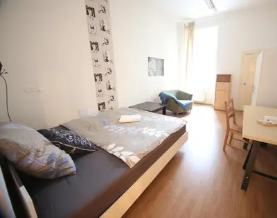 a bedroom with a bed and a living room at Vltava Apartments Prague 7 in Prague
