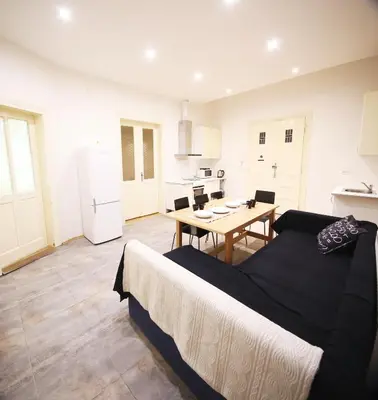a room with a bed and a table and a kitchen at Vltava Apartments Prague 7 in Prague