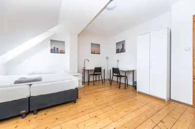 a white bedroom with a bed and a desk at Slavikova Residence in Prague