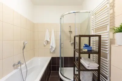 a bathroom with a bath tub and a shower at Slavikova Residence in Prague