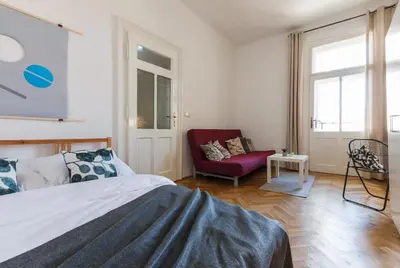 a bedroom with a bed and a red chair at Slavikova Residence in Prague