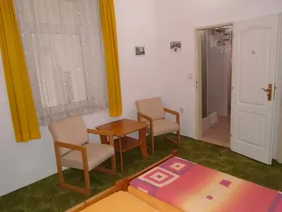 a room with two chairs and a table and a door at Pension Dobroucky in Prague