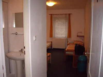 a bathroom with a sink and a toilet and a bed at Pension Dobroucky in Prague