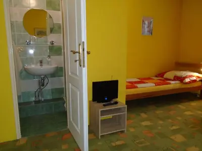 a bathroom with a sink and a bed and a television at Pension Dobroucky in Prague