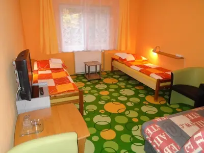a small room with two beds and a table at Pension Dobroucky in Prague