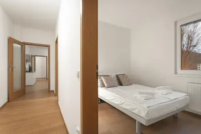 a small bedroom with a bed and a mirror at Prague City Residence in Prague