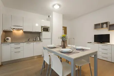 a kitchen with white cabinets and a table and chairs at Prague City Residence in Prague