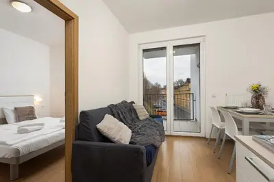 a living room with a couch and a bed and a kitchen at Prague City Residence in Prague