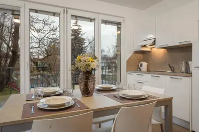 a kitchen with a table with chairs and a vase of flowers at Prague City Residence in Prague