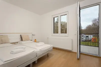 a white room with two beds and a window at Prague City Residence in Prague