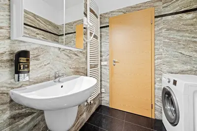 a bathroom with a sink and a washing machine at Prague City Residence in Prague