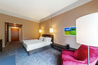 a hotel room with a bed and a chair at NH Collection Prague in Prague