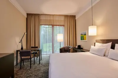 a hotel room with a large bed and a desk at NH Collection Prague in Prague