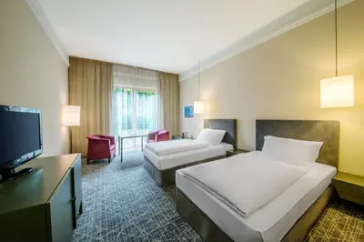 a hotel room with two beds and a flat screen tv at NH Collection Prague in Prague