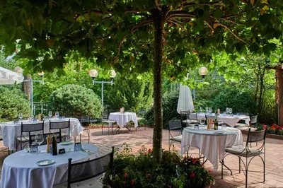 a table set up for a wedding under a tree at NH Collection Prague in Prague