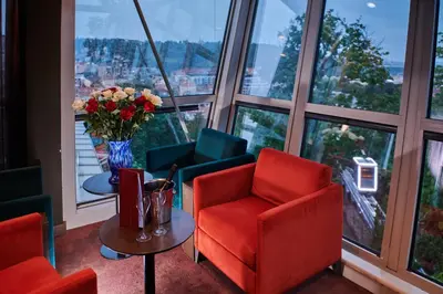 a room with a red chair and a table with flowers at NH Collection Prague in Prague
