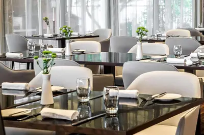 a dining room with tables and chairs with glasses at NH Collection Prague in Prague