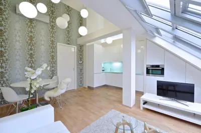 a living room with white furniture and a tv at Designer Loft 2 in Prague