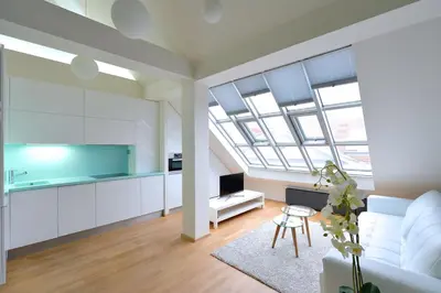 a living room with a white couch and a kitchen at Designer Loft 2 in Prague