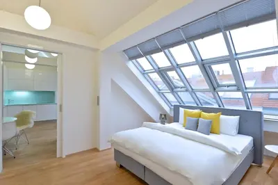 a bedroom with a large bed with yellow pillows at Designer Loft 2 in Prague