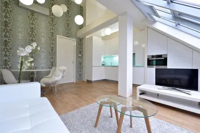 a living room with a white couch and a tv at Designer Loft 2 in Prague