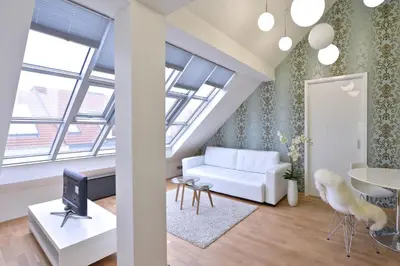 a living room with a white couch and a tv at Designer Loft 2 in Prague