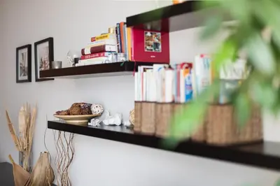 a shelf with books and a plate of food on it at The SUNNY PRAGUE APPARTMENT&Garage in Prague