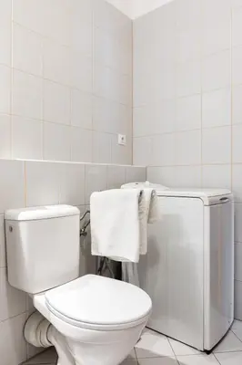 a white bathroom with a toilet and towels at The SUNNY PRAGUE APPARTMENT&Garage in Prague