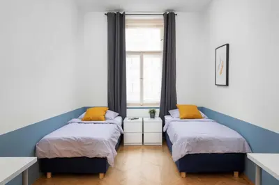 two beds in a room with a window at Letná Apartments in Prague