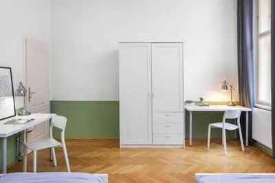 a bedroom with a desk and a white cabinet at Letná Apartments in Prague