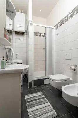 a bathroom with a sink and a toilet and a shower at Letná Apartments in Prague