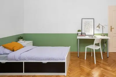 a bedroom with a bed and a table and a desk at Letná Apartments in Prague