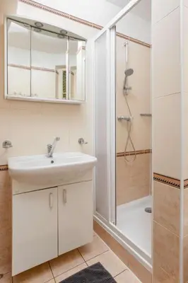 a white bathroom with a sink and a shower at Letná Apartments in Prague
