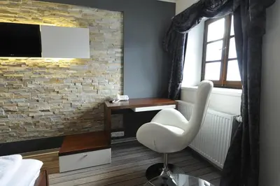 a room with a chair and a desk and a television at Caramell in Louny