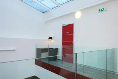 an office with a glass partition and a red cabinet at Caramell in Louny