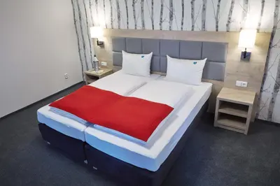 a bedroom with a large bed with a red blanket at Penzion Archery in Nová Ves