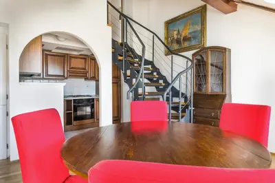 a dining room with a wooden table and red chairs at La Fenice in Prague