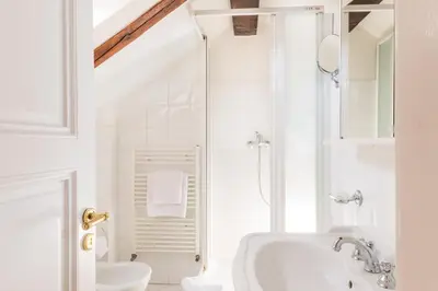 a white bathroom with a shower and a sink at La Fenice in Prague
