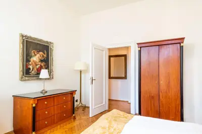 a bedroom with a bed and a dresser and a door at La Fenice in Prague