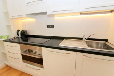 a kitchen with white cabinets and a sink at Luxury apartments Krocínova in Prague