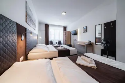 a hotel room with two beds and a bathroom at Penzion Homér Slaný in Slaný