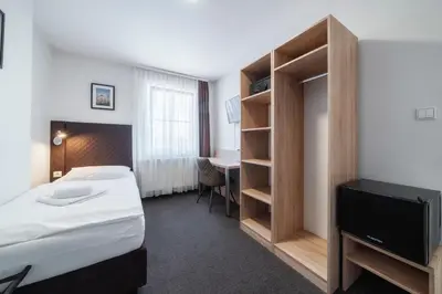 a hotel room with a bed and a tv at Penzion Homér Slaný in Slaný