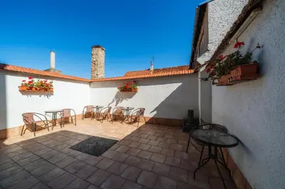 a patio with chairs and tables on a building at Penzion Homér Slaný in Slaný