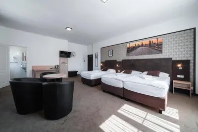 a hotel room with two beds and a desk at Penzion Homér Slaný in Slaný