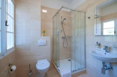 a bathroom with a shower and a toilet and a sink at Art Deco Hotel Hoffmann in Kladno