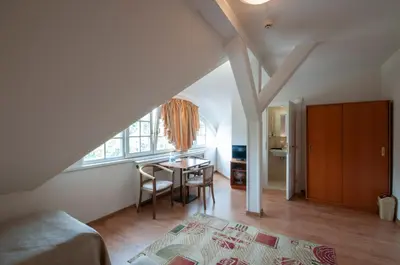 a bedroom with a bed and a table and a window at Art Deco Hotel Hoffmann in Kladno