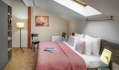 a bedroom with a large bed with white pillows at 6 Continents Apartments by Adrez in Prague